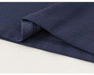 Détail de l'ourlet du t-shirt en coton bleu marine avec des finitions à double couture