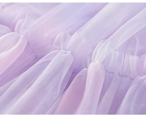 Vue détaillée du tissu en tulle lilas avec plis délicats pour robe de jeune fille