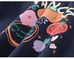 Gros plan du tissu de t-shirt marine pour enfant avec imprimés fraises et fleurs