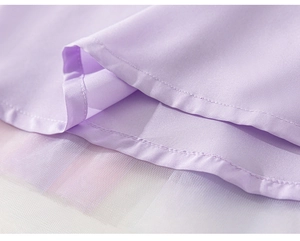 Détail de robe violet clair montrant les coutures et l'ourlet en tulle blanc superposé