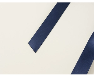 Detail der dunkelblauen Satin-Schleife am karierten Mädchenkleid mit glatter Textur