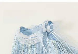 Détail d'une robe en maille bleu clair avec col en dentelle et nœud en tulle délicat