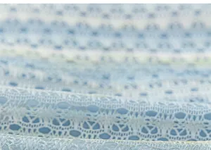 Vue détaillée de la dentelle bleu clair avec des motifs ajourés et du tulle