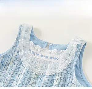 Gros plan sur le col en dentelle blanche et l'encolure à volants de la robe en maille bleue