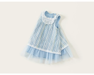 Détail d'une robe bleue pour enfant avec dentelle blanche et superposition en tulle doux