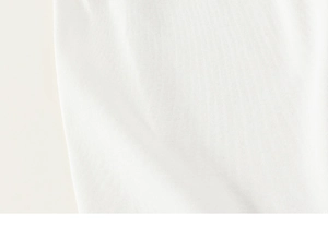 Gros plan sur la texture du tissu en coton blanc avec plis doux et tricotage haute densité