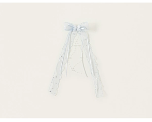 Détail d'un accessoire cheveux nœud bleu clair avec étoiles argentées et perles