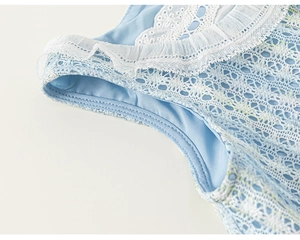 Vue macro détaillée des broderies en dentelle blanche sur la robe en tulle bleu clair fille