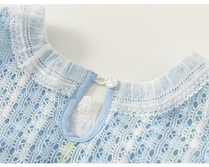 Détail du col en dentelle bleu clair avec volants blancs et boutonnière en goutte d'eau