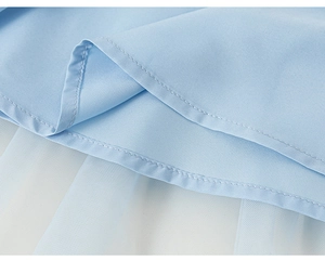 Détail de jupe en tulle bleu clair montrant des coutures fines et un tissu de gaze
