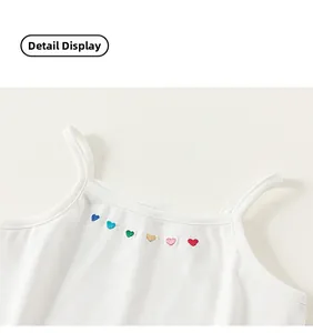 Détail d'un débardeur en coton blanc avec de petites broderies de cœurs colorés
