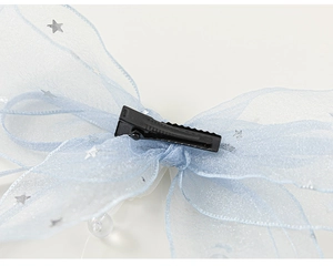 Détail de la barrette en tulle bleu clair avec étoiles argentées et clip en métal