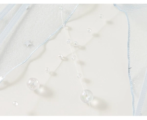 Détail du tissu en maille bleu clair avec perles transparentes et étoiles argentées