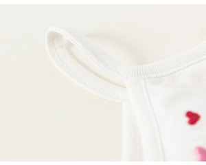 Gros plan d'un débardeur en coton blanc pour fille avec broderie de deux cœurs