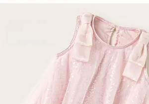 Dettaglio vestito in tulle rosa per bambina con paillettes argento e fiocchi di raso