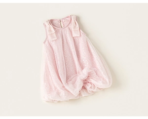 Dettaglio dell'abito in tulle rosa con paillettes scintillanti e fiocchi di raso sulle spalle