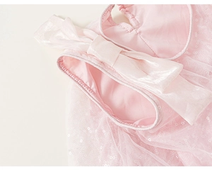 Dettaglio del tulle con paillettes e fiocco di raso su questo abito da principessa rosa