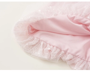 Dettaglio macro della gonna in tulle rosa con paillettes argento e fodera in raso