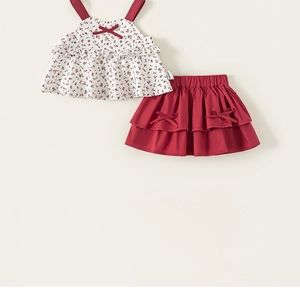 Close-up of floral camisole top with red bow and tiered skirt set for girls