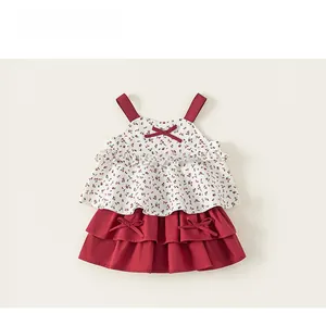 Close-up detail of girls red floral top with bow and tiered ruffled skirt set