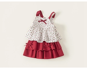 Detail of floral ruffle top and red tiered skirt set for girls with bow accents