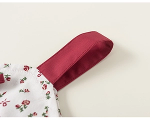 Detail view of burgundy shoulder strap and delicate red floral cotton fabric stitching
