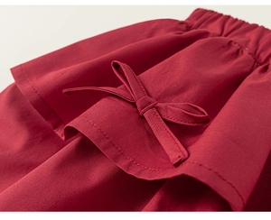 Detailed macro view of girls' dark red floral cotton skirt with elastic waist and bow