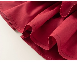 Close-up of red floral girl set showing detailed stitching and pleated fabric texture