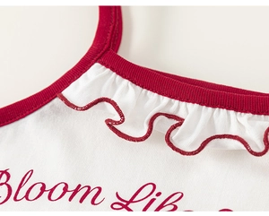 Détail d'un débardeur fille avec bordure rouge et col à volants en dentelle