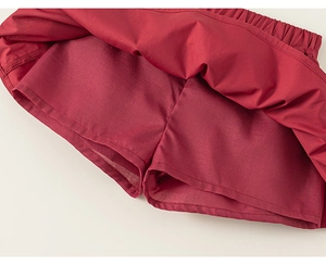 Detail of dark red girls' skort with elastic waist and built-in safety shorts liner