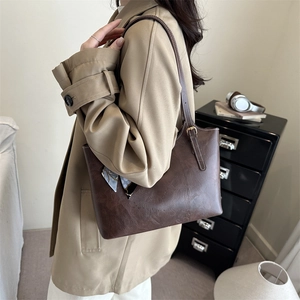 Brown faux leather tote bag with silk scarf accessory and adjustable shoulder strap