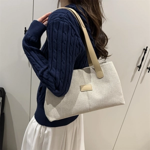 Linen patchwork tote bag with leather straps on model in minimalist interior setting