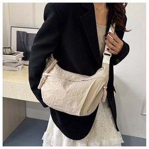 Dettaglio borsa a tracolla a mezzaluna beige in nylon con trama e tirazip intrecciato