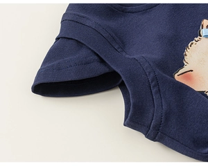 Dettaglio maglietta in cotone blu con stampa a cartoni e fiocco in nastro blu