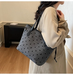 Polished grey tote bag with black polka dots and small bow embroidery shown on model
