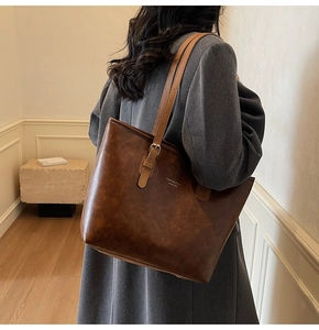 Brown vintage wax leather tote bag shown on model for office commute lifestyle