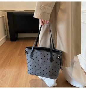 Detailed view of grey tote bag featuring black polka dots and small bow embroidery