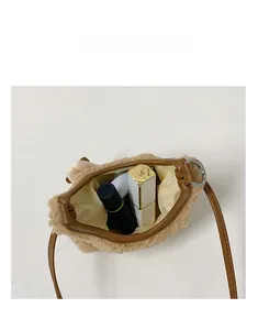 Vue de dessus du sac bandoulière en peluche montrant la capacité avec un rouge à lèvres