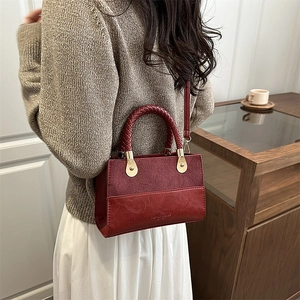 Burgundy faux leather handbag with leopard print strap and gold buckles shown on model