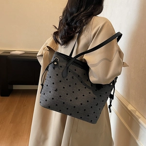 Polka dot pattern tote bag with bow embroidery and leather strap in minimalist interior