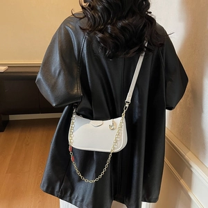 White pebbled leather crescent crossbody bag with gold chain and adjustable strap