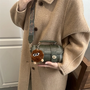 Vintage dark green cylinder crossbody bag with golden studs and wide geometric strap