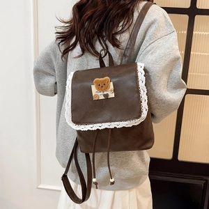 Vintage brown leather backpack with delicate white lace trim and cute bear patch