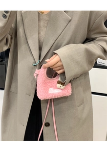 Mini borsa rosa in sherpa con ricamo Cute e ciondolo a orsetto tenuta da modella