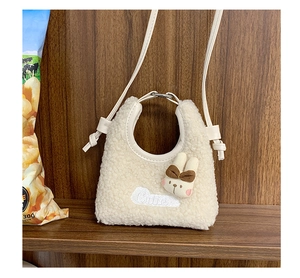 Dettaglio della borsa a tracolla in peluche beige con ricamo Cute e decorazione a coniglio