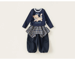 Dettaglio della felpa blu navy con stampa gatto e pantaloni con gonna a quadri sovrapposta