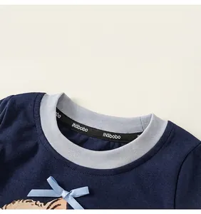 Dettaglio maglia bimbi blu navy con colletto a costine e fiocco in seta azzurro