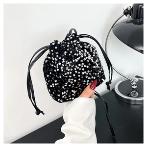 Détail d'un sac seau élégant à paillettes avec fermeture par cordon et finitions brillantes
