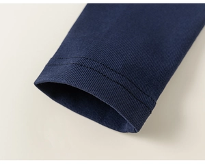 Dettaglio dei polsini a coste blu navy e doppia cucitura sul completo in cotone per bambina