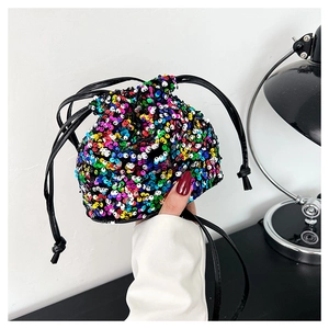 Détail d'un sac seau à paillettes multicolores avec fermeture à cordon et design chic